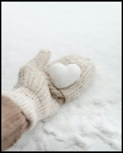 Ein Leinwandbild von einer behandschuhten Hand, die ein kleines Herz aus Schnee hält.